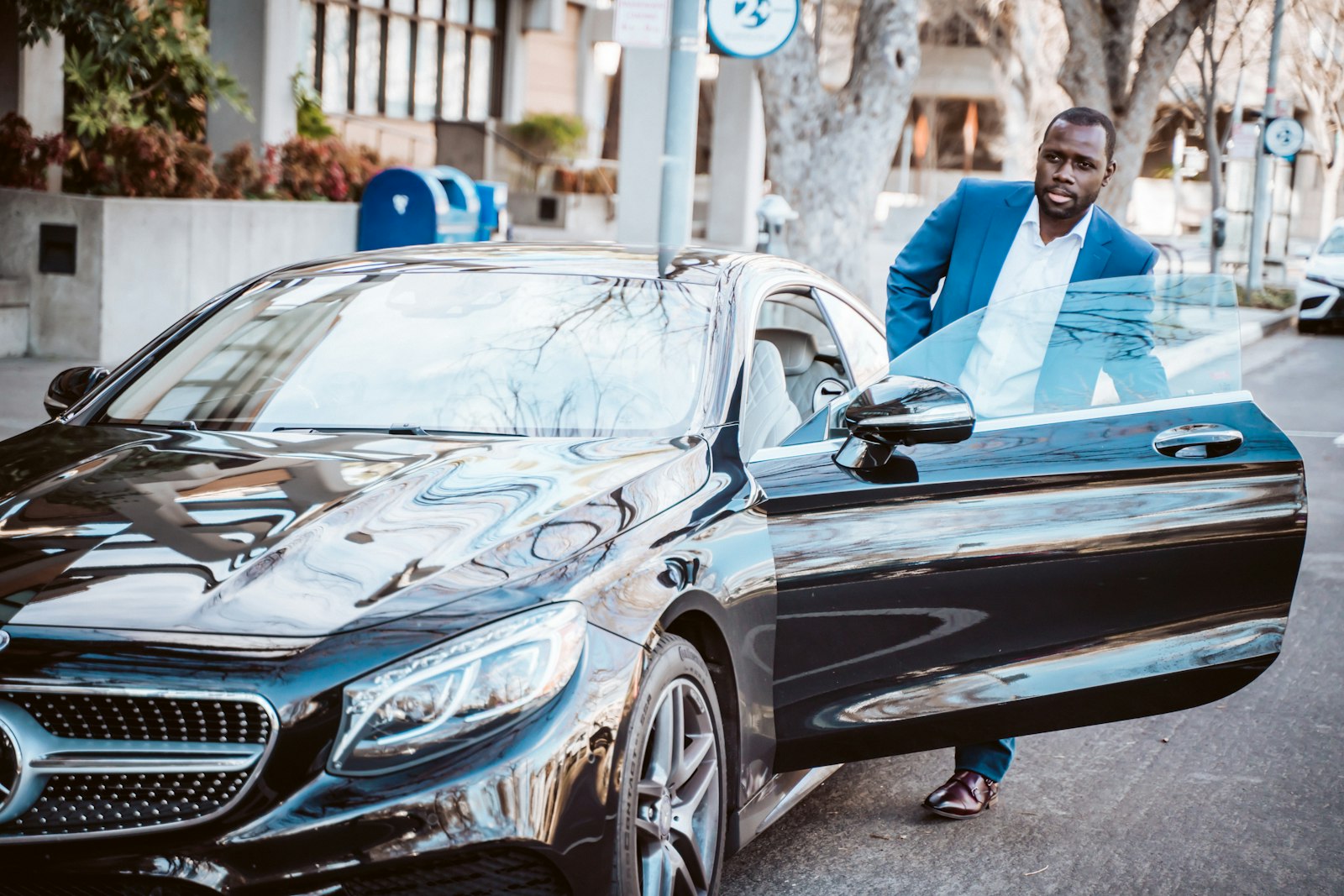Professional driver beside a luxury car for half-day city trips
